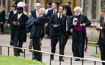 RETRANSMITTING PICTURE UPDATING CAPTION Nick Cave (centre) and former Archbishop of Canterbury Rowan Williams (right) arriving ahead of the coronation ceremony of King Charles III and Queen Camilla at Westminster Abbey, London. Picture date: Saturday May 6, 2023.