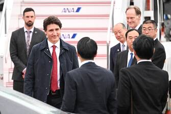Canada's Prime Minister Justin Trudeau (2nd L) is welcomed by officials upon his arrival at Hiroshima airport in Mihara, Hiroshima prefecture on May 18, 2023, to attend the G7 Leaders' Summit. (Photo by Yuichi YAMAZAKI / AFP) (Photo by YUICHI YAMAZAKI/AFP via Getty Images)