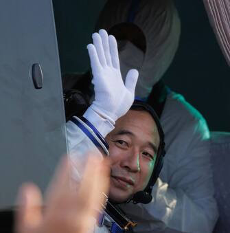 epa10662670 Commander Jing Haipeng waves during the seeing-off ceremony before boarding for the launch of the Long March-2F carrier rocket with a Shenzhou-16 manned space flight at the Jiuquan Satellite Launch Centre, in Jiuquan, Gansu province, China, 30 May 2023. The Shenzhou-16 manned space flight mission will transport three Chinese astronauts to the Tiangong space station.  EPA/ALEX PLAVEVSKI