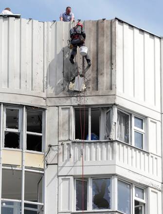 epa10663066 Workers repare a damaged residential building following a reported drone attack in Moscow, Russia, 30 May 2023. An unmanned aerial vehicle (UAV) attack caused 'minor' damage to several buildings and no serious injuries following a drone strike in the Russian capital, Moscow Mayor Sergei Sobyanin wrote on telegram. 'This morning, the Kyiv regime launched a terrorist attack with unmanned aerial vehicles on facilities in the city of Moscow', said the Russian Defence Ministry blaming the attack on Ukraine. The Russian military intercepted eight drones targeting facilities in the city of Moscow, the defense ministry added.  EPA/MAXIM SHIPENKOV