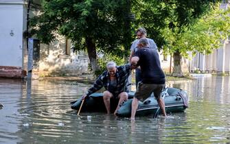 epa10676353 People help an elderly man to get in an inflatable boat as he evacuates from his home in a flooded street of Kherson, Ukraine, 06 June 2023.  Ukraine has accused Russian forces of destroying a critical dam and hydroelectric power plant on the Dnipro River in the Kherson region along the front line in southern Ukraine on 06 June. A number of settlements were completely or partially flooded, Kherson region governor Oleksandr Prokudin said on telegram. Russian troops entered Ukraine on 24 February 2022 starting a conflict that has provoked destruction and a humanitarian crisis.  EPA/IVAN ANTYPENKO