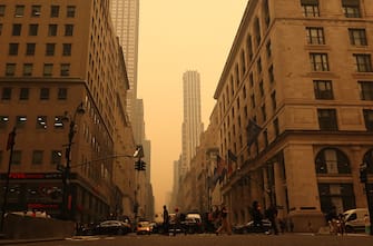 NEW YORK, NY - JUNE 7: People cross 5th Avenue as heavy smoke fills the air on June 7, 2023, in New York City.  (Photo by Gary Hershorn/Getty Images)