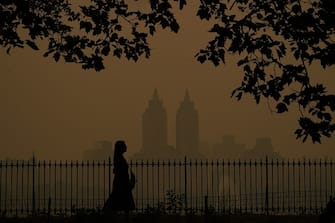 TOPSHOT - People walk in Central Park as smoke from wildfires in Canada cause hazy conditions in New York City on June 7, 2023. Smoke from Canada's wildfires has engulfed the Northeast and Mid-Atlantic regions of the US, raising concerns over the harms of persistent poor air quality. (Photo by TIMOTHY A. CLARY / AFP) (Photo by TIMOTHY A. CLARY/AFP via Getty Images)