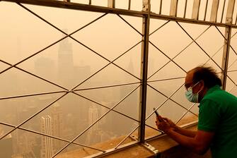NEW YORK, NY - JUNE 7: Heavy smoke fills the air shrouding the view to the northeast to One Vanderbilt and the Chrysler Building from the 86th floor of the Empire State Building as a person tries to take a picture on June 7, 2023, in New York City.  (Photo by Gary Hershorn/Getty Images)