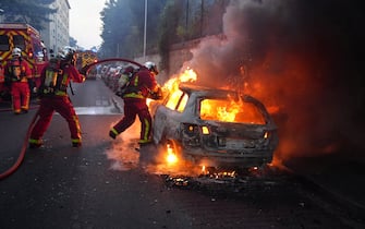 TOPSHOT - Firefighters work to put out a burning car on the sidelines of a demonstration in Nanterre, west of Paris, on June 27, 2023, after French police killed a teenager who refused to stop for a traffic check in the city. The 17-year-old was in the Paris suburb early on June 27 when police shot him dead after he broke road rules and failed to stop, prosecutors said. The event has prompted expressions of shock and questions over the readiness of security forces to pull the trigger. (Photo by Zakaria ABDELKAFI / AFP) (Photo by ZAKARIA ABDELKAFI/AFP via Getty Images)