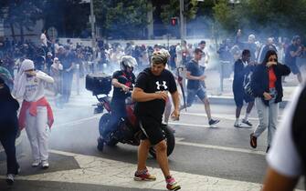 epa10717462 People run from tear gas during clashes with French riot police on the sidelines of a march in the memory of 17-year-old Nahel, who was killed by French Police in Nanterre, near Paris, France, 29 June 2023. Violence broke out after the police fatally shot a 17-year-old during a traffic stop in Nanterre on 27 June. According to the French interior minister, 31 people were arrested with 2,000 officers being deployed to prevent further violence. EPA/YOAN VALAT