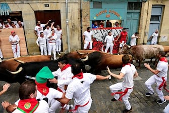 Participants run ahead of bulls during the first 