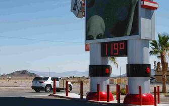 epa10748749 A car moves by a thermometer showing 119 degrees Farenheit in Baker, California, USA, 15 July 2023. A heatwave is hitting the southwestern United States and is expected to bring temperatures above 120 degrees Fahrenheit (48.8 Celsius) in parts of California and Arizona in the coming days.  EPA/CAROLINE BREHMAN