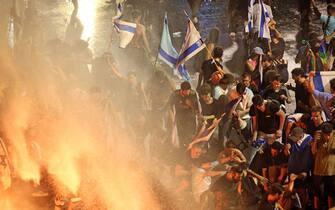 Demonstrators are sprayed with water cannons by Israeli riot police during a protest against the Israeli government's judicial reform plan in Tel Aviv on July 24, 2023. Israeli lawmakers on July 24 approved a key clause of a controversial judicial reform plan that aims to curb the powers of the Supreme Court in striking down government decisions. (Photo by JACK GUEZ / AFP) (Photo by JACK GUEZ/AFP via Getty Images)
