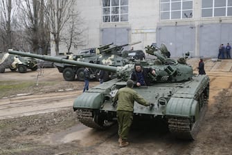 epa05079478 Ukrainian workers talk near a tank which was delivered for repair at the armored vehicles factory in Kiev, Ukraine, 23 December 2015. The United States a day earlier expanded its list of Russian individuals and entities sanctioned over the Ukraine conflict in an effort to push Russia to enforce a ceasefire deal clinched earlier this year in Minsk. The sanctions also include six pro-Russian separatists and two former Ukrainian officials close to Ukraine's ousted pro-Russian president Viktor Yanukovych. Ukraine ousted Yanukovych last year amid mass protests calling for closer ties with the West. Russia subsequently annexed Ukraine's southern Crimea region and supported a pro-Russian separatist rebellion in Ukraine's two eastern-most regions.  EPA/SERGEY DOLZHENKO