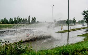 A car drives through floodwater at an highway exit on the E6 nearby Klofta, north of Oslo, on August 7, 2023, as storm Hans has been categorized as red weather warning in south-east Norway.  (Photo by Stian Lysberg Solum / NTB / AFP) / Norway OUT (Photo by STIAN LYSBERG SOLUM/NTB/AFP via Getty Images)