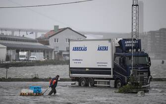 A man tears some goods towards a truck in the flooded area of ​​the fishing port Fiskhamnen where the Gota Alv river overflowed in Gothenburg, Sweden, on August 08, 2023, after heavy rainfalls as a result of the extreme weather 