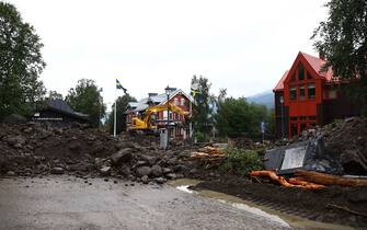 An excavator clears debris after the Susa River running through Are, northern Sweden, overflowed following heavy rainfall due to extreme weather 'Hans' on August 8, 2023. Large amounts of water an soil have rushed through the village causing damage to properties and roads.  (Photo by Johan Axelsson / TT News Agency / AFP) / Sweden OUT (Photo by JOHAN AXELSSON/TT News Agency/AFP via Getty Images)