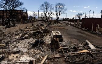 epa10802242 Burned out cars and houses are all that remains after a wildfire swept through a neighborhood in Lahaina, Hawaii, USA, 15 August 2023. At least 99 people were killed in the Lahaina wildfire that burnt in Maui, which is considered the largest natural disaster in Hawaii's state history.  EPA/ETIENNE LAURENT