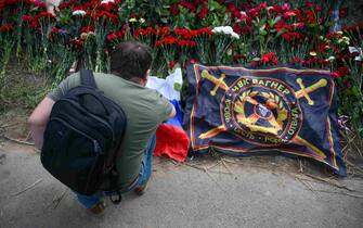 epa10817447 A man brings flowers and flag at an informal memorial next to the former 'PMC Wagner Centre' in St. Petersburg, Russia, 24 August 2023. An investigation was launched into the crash of an aircraft in the Tver region in Russia on 23 August 2023, the Russian Federal Air Transport Agency said in a statement. Among the passengers was Wagner chief Yevgeny Prigozhin, the agency reported.  EPA/ANTON MATROSOV