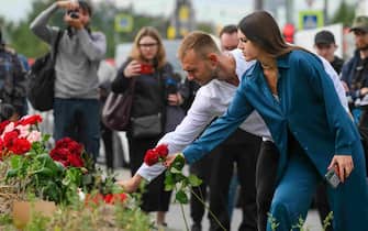epa10817436 People bring flowers at an informal memorial next to the former 'PMC Wagner Centre' in St. Petersburg, Russia, 24 August 2023. An investigation was launched into the crash of an aircraft in the Tver region in Russia on 23 August 2023, the Russian Federal Air Transport Agency said in a statement. Among the passengers was Wagner chief Yevgeny Prigozhin, the agency reported.  EPA/ANTON MATROSOV