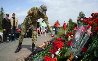 epa10817445 A man brings flowers at an informal memorial next to the former 'PMC Wagner Centre' in St. Petersburg, Russia, 24 August 2023. An investigation was launched into the crash of an aircraft in the Tver region in Russia on 23 August 2023, the Russian Federal Air Transport Agency said in a statement. Among the passengers was Wagner chief Yevgeny Prigozhin, the agency reported.  EPA/ANTON MATROSOV