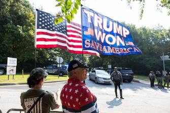 ATLANTA, GEORGIA - AUGUST 24:  Supporters of former President Donald Trump, Georgina and Cliff MacMorris hold flags outside of the Fulton County Jail ahead of Trump's surrender on August 24, 2023 in Atlanta, Georgia. Trump and 18 others facing felony charges in the case related to the tampering of the 2020 Election in Georgia must surrender to authorities by August 25th. (Photo by Jessica McGowan/Getty Images)