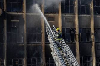 EDITORS NOTE: Graphic content / A firefighter extinguishes the fire at a building in Johannesburg on August 31, 2023. At least 20 people have died and more than 40 were injured in a fire that engulfed a five-storey building in central Johannesburg on August 31 , 2023, the South African city's emergency services said.  (Photo by Michele Spatari / AFP) (Photo by MICHELE SPATARI/AFP via Getty Images)