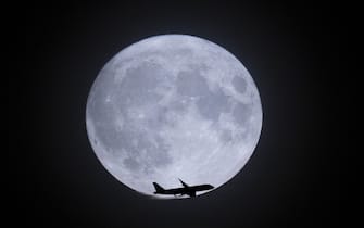 LONDON, UNITED KINGDOM - AUGUST 30: A plane flying over the rare Super Blue Moon as it illuminates the night sky in London, United Kingdom on August 30, 2023. (Photo by Rasid Necati Aslim/Anadolu Agency via Getty Images)