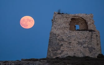 The 'Blue Supermoon' is rising over the Tower of Roca Vecchia in Roca Vecchia, Lecce, Italy, on August 30, 2023. This is the second supermoon to be observed in August and is also known as a Blue Moon.  (Photo by Manuel Romano/NurPhoto via Getty Images)