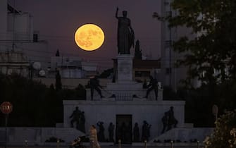 A sturgeon supermoon rises behind the Liberty Monument in Nicosia on August 1, 2023. (Photo by Amir MAKAR / AFP) (Photo by AMIR MAKAR/AFP via Getty Images)