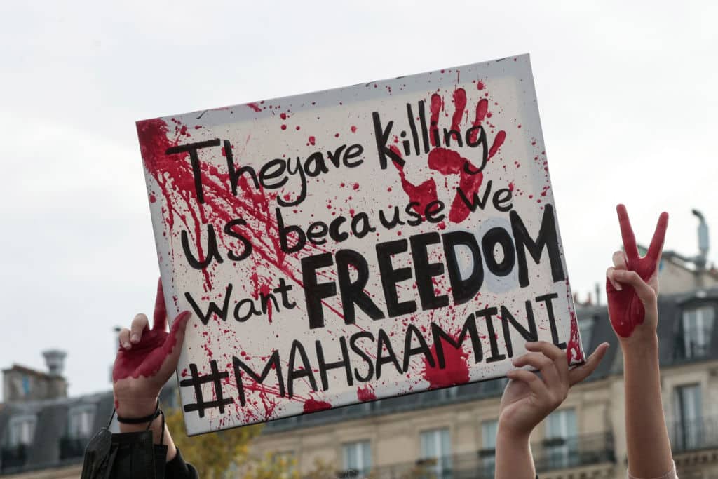 A placard is held up during a rally in support of the demonstrations in Iran, at The Place de la Republique in Paris, on October 29, 2022. - Iranian Mahsa Amini, 22, died in custody on September 16, 2022, three days after her arrest by the notorious morality police in Tehran for allegedly breaching the Islamic republic's strict dress code for women. (Photo by Geoffroy VAN DER HASSELT / AFP) (Photo by GEOFFROY VAN DER HASSELT/AFP via Getty Images)