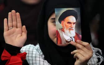 06 February 2019, Lebanon, Beirut: A supporter of Hezbollah, the pro-Iranian Lebanese Islamist political party and militant group, holds a picture of Ayatollah Khomeini, former Supreme Leader of Iran and leader of the 1979 Iranian Revolution, during a rally to mark the 40th anniversary of the Iranian Islamic Revolution which toppled Mohammad Reza Pahlavi, the last Shah of Iran.  Photo: Marwan Naamani/dpa