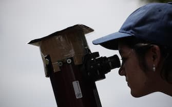 epa10919435 An astronomy enthusiast observes the annular solar eclipse, at the Observatory of the Technological University of Panama in the province of Cocle, Panama, 14 October 2023. An annular solar eclipse crossed America from North to South on 14 October.  EPA/Bienvenido Velasco
