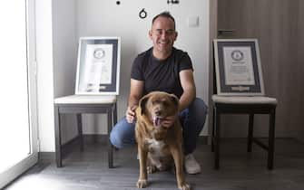 LEIRIA, PORTUGAL - JULY 2: Leonel Costa, owner, and 31-year-old dog Bobi pose with Guinness World Record certificates in Leiria, Portugal on July 2, 2023. Bobi holds the Guinness World Record for the oldest living dog and has never been chained or leashed and has always enjoyed free roaming in the forests and farmland surrounding his owner's house.  (Photo by Luis Boza/Anadolu Agency via Getty Images)