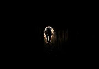 TOPSHOT - A member of the Palestinian Islamic Jihad militant group enters a tunnel in the Gaza strip, on April 17, 2022, during a media tour amid escalating violence with Israel.  - More than 20 Palestinians and Israelis were wounded in several incidents in and around Jerusalem's flashpoint Al-Aqsa Mosque complex, two days after major violence at the site.  (Photo by Mahmud HAMS / AFP) (Photo by MAHMUD HAMS/AFP via Getty Images)