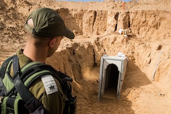 A picture taken on January 18, 2018 from the Israeli side of the border with the Gaza Strip shows an Israeli army officer walking near the entrance of a tunnel, that Israel says was dug by the Islamic Jihad group, leading from the Palestinian enclave into Israel , near southern Israeli kibbutz of Kissufim.  Israel uncovered and destroyed the tunnel in late October.  (Photo by JACK GUEZ / POOL / AFP) (Photo by JACK GUEZ/POOL/AFP via Getty Images)