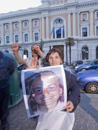 The mother of Elisa Claps shows a photo of her daughter as she leaves the court in Salerno, 24 April 2013. For the murder of the student from Potenza Elisa Claps, which occurred in Potenza on 12 September 1993, the Assize Court of Appeal of Salerno confirmed the sentence of 30 years' imprisonment, with an abbreviated sentence, for Danilo Restivo.  The prosecution's reasons were thus accepted and the defense arguments of the accused's innocence were rejected.  ANSA/CIRO FUSCO