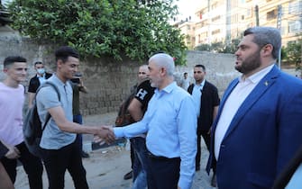 Yahya Sinwar, leader of the Palestinian Hamas movement's political wing, greets supporters as he tours the Al-Rimal neighborhood in Gaza City, on May 26, 2021, to assess the damage caused during the recent bombing by Israeli forces.  - Hamas vowed today not to touch 