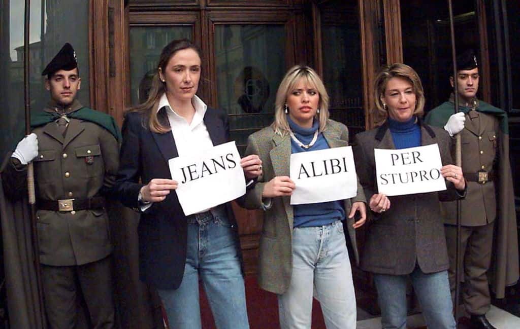 Italian deputies Stefania Prestigiacomo (L) of the Forza Italia party, Alessandra Mussolini (C) and Sandra Fei (R) of the neo-fascist Allianza Nazionale party hold 11 February placards, spelling out the slogan "Jeans alibi for rape" to protest against a 10 February ruling by the Supreme Court of Appeals that a woman wearing jeans cannot claim to have been raped. Female lawmakers continued their "no -skirt strike" to protest the ruling, which sparked a storm of protests across Italy. (Photo by TOIATI / AFP) (Photo by TOIATI/AFP via Getty Images)