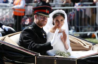 WINDSOR, ENGLAND - MAY 19: (EDITORS NOTE: Retransmission of #960087582 with alternate crop.) Prince Harry, Duke of Sussex and Meghan, Duchess of Sussex wave from the Ascot Landau Carriage during their carriage procession on Castle Hill outside Windsor Castle in Windsor, on May 19, 2018 after their wedding ceremony.  (Photo by Aaron Chown - WPA Pool/Getty Images)