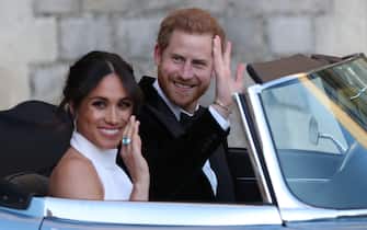 WINDSOR, UNITED KINGDOM - MAY 19: Duchess of Sussex and Prince Harry, Duke of Sussex wave as they leave Windsor Castle after their wedding to attend an evening reception at Frogmore House, hosted by the Prince of Wales on May 19, 2018 in Windsor, England. (Photo by Steve Parsons - WPA Pool/Getty Images)
