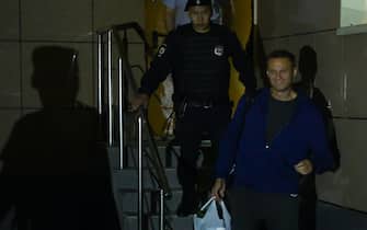1157607372 Russian opposition leader Alexei Navalny leaves a court surrounded by a police officer after being sentenced to 30 days in jail for repeatedly violating demonstration regulations, Moscow, July 24, 2019. (Photo by Kirill KUDRYAVTSEV / AFP) (Photo credit should read KIRILL KUDRYAVTSEV/AFP via Getty Images)