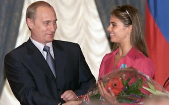 Russian President Vladimir Putin (L) hands flowers to Alina Kabayeva, Russian rhytmic gymnastics star and Olympic prize winner, after awarding her with an Order of Friendship during annual award ceremony in the Kremlin 08 June 2001.   AFP PHOTO     EPA POOL/SERGEI CHIRIKOV        (Photo credit should read SERGEI CHIRIKOV/AFP via Getty Images)