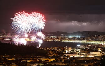TOPSHOT - A picture taken on July 14, 2016 shows a flash of lightning as fireworks explode over the French riviera city of Nice, southeastern France, as part of France's annual Bastille Day Celebrations. / AFP / VALERY HACHE        (Photo credit should read VALERY HACHE/AFP via Getty Images)