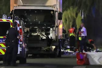 EDITORS NOTE: Graphic content / Police officers stand near a truck, with its windscreen riddled with bullets, that ploughed into a crowd leaving a fireworks display in the French Riviera town of Nice on July 14, 2016.
At least 60 people were killed when a truck ploughed into a crowd watching a Bastille Day fireworks display in the southern French resort of Nice, prosecutors said early on July 15. Nice prosecutor Jean-Michel Pretre said the truck drove two kilometres (1.3 miles) through a large crowd that was watching the fireworks.
 / AFP PHOTO / VALERY HACHE        (Photo credit should read VALERY HACHE/AFP via Getty Images)
