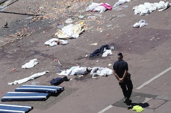 French gendarmes walk past clothes and mattresses at the site of the deadly attack on the Promenade des Anglais seafront in the French Riviera city of Nice on July 15, 2016, after a gunman smashed a truck through a crowd celebrating Bastille Day, killing at least 84 and injuring dozens of children in what President Francois Hollande called a "terrorist" attack.
Hollande declared three days of mourning after the assault, as the shellshocked country found itself again mourning its dead after attacks on Charlie Hebdo magazine in January 2015 and the November 2015 massacre in Paris.  / AFP / Valery HACHE        (Photo credit should read VALERY HACHE/AFP via Getty Images)