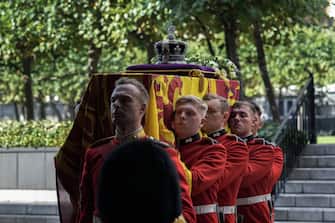 LONDON, ENGLAND - SEPTEMBER 14:  Pallbearers carry the coffin of Britain's Queen Elizabeth as it arrives at Westminster Hall from Buckingham Palace for her lying in state, on September 14, 2022 in London, United Kingdom. Queen Elizabeth II's coffin is taken in procession on a Gun Carriage of The King's Troop Royal Horse Artillery from Buckingham Palace to Westminster Hall where she will lay in state until the early morning of her funeral. Queen Elizabeth II died at Balmoral Castle in Scotland on September 8, 2022, and is succeeded by her eldest son, King Charles III. (Photo by Emilio Morenatti - WPA Pool/Getty Images)