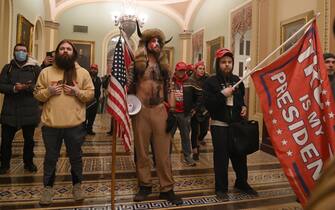 TOPSHOT - Supporters of US President Donald Trump, including member of the QAnon conspiracy group Jake Angeli, aka Yellowstone Wolf (C), enter the US Capitol on January 6, 2021, in Washington, DC. - Demonstrators breeched security and entered the Capitol as Congress debated the a 2020 presidential election Electoral Vote Certification. (Photo by Saul LOEB / AFP) (Photo by SAUL LOEB/AFP via Getty Images)