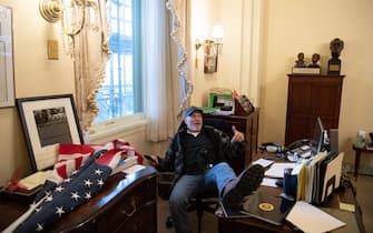 TOPSHOT - Richard Barnett, a supporter of US President Donald Trump sits inside the office of US Speaker of the House Nancy Pelosi as he protest inside the US Capitol in Washington, DC, January 6, 2021. - Demonstrators breeched security and entered the Capitol as Congress debated the a 2020 presidential election Electoral Vote Certification. (Photo by SAUL LOEB / AFP) (Photo by SAUL LOEB/AFP via Getty Images)