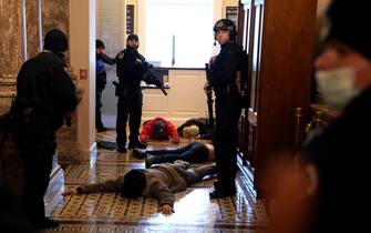 1294930640 WASHINGTON, DC - JANUARY 06: U.S. Capitol Police stand detain protesters outside of the House Chamber during a joint session of Congress on January 06, 2021 in Washington, DC. Congress held a joint session today to ratify President-elect Joe Biden's 306-232 Electoral College win over President Donald Trump. A group of Republican senators said they would reject the Electoral College votes of several states unless Congress appointed a commission to audit the election results. (Photo by Drew Angerer/Getty Images)