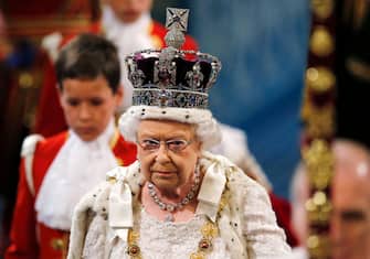 Britain's Queen Elizabeth II, wearing the Imperial State Crown, proceeds through the Royal Gallery during the State Opening of Parliament at the Palace of Westminster in central London on May 27, 2015. - The State Opening of Parliament marks the formal start of the parliamentary year and the Queen's Speech sets out the governments agenda for the coming session. (Photo by SUZANNE PLUNKETT / POOL / AFP) (Photo by SUZANNE PLUNKETT/POOL/AFP via Getty Images)