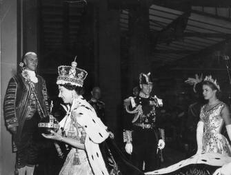 3071456 2nd June 1953: Queen Elizabeth II, wearing the Imperial State crown and carrying the Orb and Sceptre, returns to Buckingham Palace from Westminster Abbey, London, following her Coronation. (Photo by Topical Press Agency/Getty Images)
