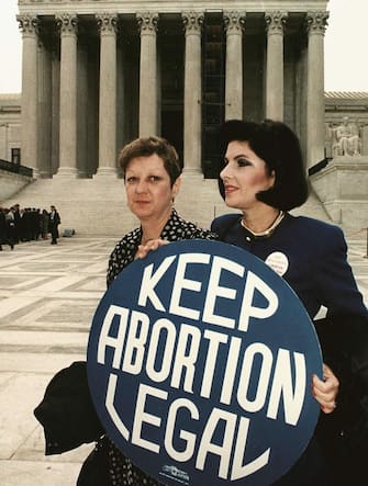 WASHINGTON, DC - APRIL 26:  This file photo shows Norma McCorvey(L) formally known as "Jane Roe",as she holds a pro-choice sign with former attorney Gloria Allred(R) in front of the US Supreme Court building 26 April 1989,in Washington,DC, just before attorneys began arguing the 1973 landmark abortion decision which legalized abortion in the US.  (Photo credit should read GREG GIBSON/AFP via Getty Images)