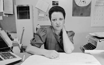 (Original Caption) Dallas: In her neat and well organized office Norma McCorvey sits behind her desk with a sign out front that says "I Am Subject To Bursts OF Enthusiasm.